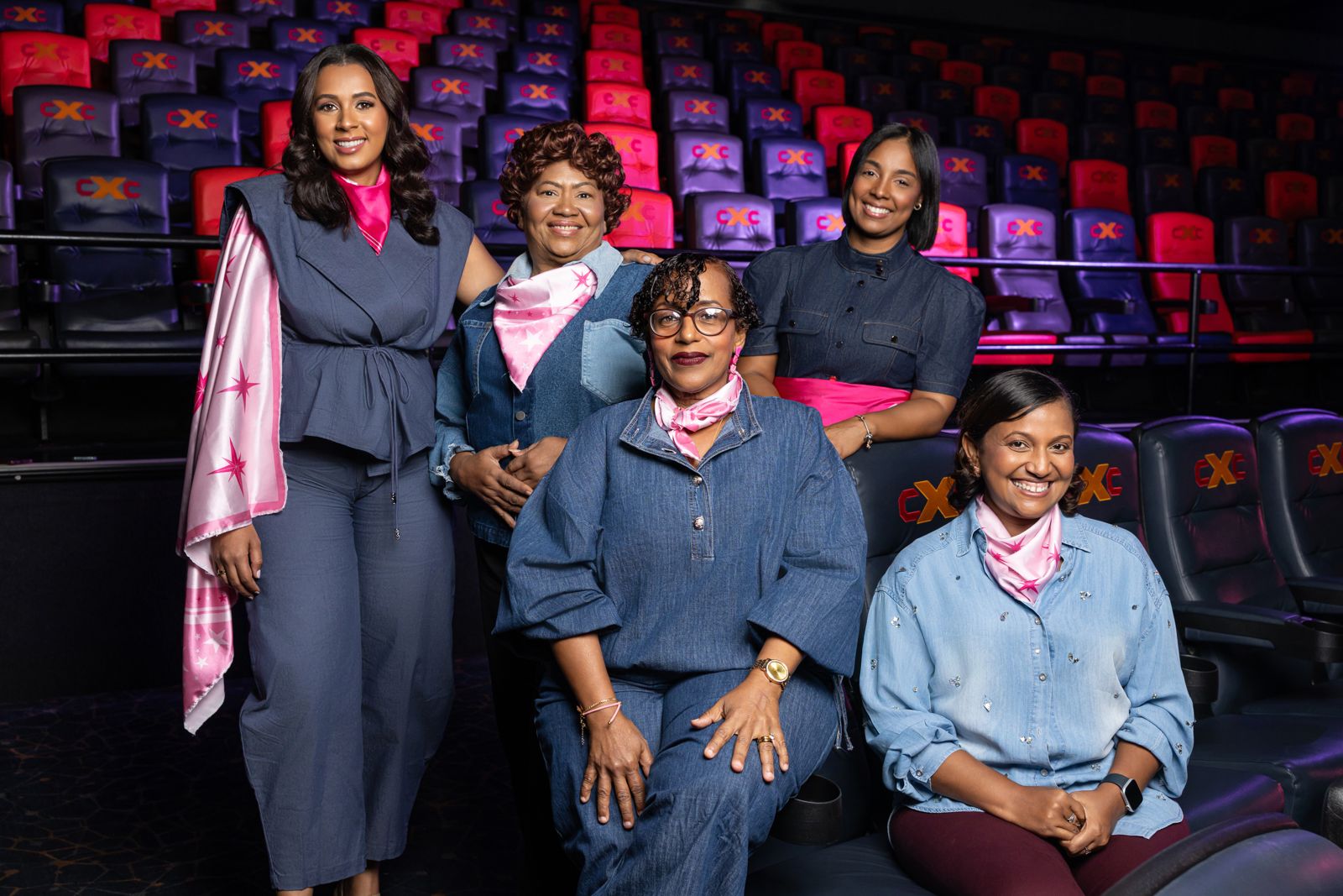 La fundadora de La Caja Rosa junto a cuatro mujeres sobrevivientes, con pañuelos rosados, en una sala de cine